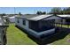 Aerial view of single-story home with screened porch and carport in a well-maintained community at 37542 Pinata Ave, Zephyrhills, FL 33541