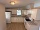 Bright kitchen features white cabinetry, stainless steel appliances, and a window view at 37542 Pinata Ave, Zephyrhills, FL 33541
