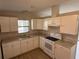 Well-lit kitchen boasts ample counter space and clean white cabinetry with modern appliances at 37542 Pinata Ave, Zephyrhills, FL 33541