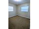Simple bedroom featuring two windows with mini blinds and neutral carpeting at 3905 W Carmen St, Tampa, FL 33609