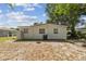 View of home's backyard and exterior with mature trees and lawn area at 4005 W Nassau St, Tampa, FL 33607