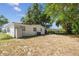 View of home's backyard and exterior with mature trees and lawn area at 4005 W Nassau St, Tampa, FL 33607