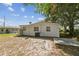 View of home's backyard and exterior with mature trees and lawn area at 4005 W Nassau St, Tampa, FL 33607
