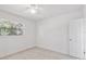 Clean bedroom with light wood-style flooring, a ceiling fan, and a large window at 4005 W Nassau St, Tampa, FL 33607