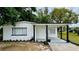 Charming single-story home with a covered porch, manicured lawn, and freshly painted white brick at 4005 W Nassau St, Tampa, FL 33607