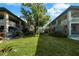A courtyard situated between two buildings, showcasing well-maintained landscaping and a large tree at 426 32Nd N Ave # 102E, St Petersburg, FL 33704