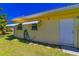 Rear exterior features a white door, awning-covered windows, and a neatly kept lawn at 5427 Springwood Blvd # 5427, Pinellas Park, FL 33782