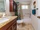 Functional bathroom featuring a vanity, toilet, and shower-tub combo with safety grab bars at 5427 Springwood Blvd # 5427, Pinellas Park, FL 33782