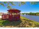 Red community gazebo overlooking a serene lake, offers a peaceful retreat for residents at 5427 Springwood Blvd # 5427, Pinellas Park, FL 33782