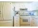 Well-organized kitchen featuring a refrigerator, range, and ample cabinet space for storage at 5427 Springwood Blvd # 5427, Pinellas Park, FL 33782