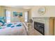 Cozy bedroom featuring a decorative fireplace, two windows, and a comfortable bed with a blue floral pattern at 5427 Springwood Blvd # 5427, Pinellas Park, FL 33782