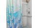Shower featuring a blue patterned shower curtain, a multi-setting shower head, and a safety grab bar at 5427 Springwood Blvd # 5427, Pinellas Park, FL 33782