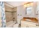 Well-lit bathroom featuring tiled walls, shower-tub combo, granite countertop, and decorative mirror at 6211 Sun Blvd # 404, St Petersburg, FL 33715