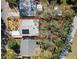 Aerial view of home with a defined property line showing backyard with mature trees, plants, and solar panels at 6327 Emerson S Ave, St Petersburg, FL 33707