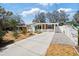 Charming single-story home featuring a manicured lawn, concrete driveway, and a delightful picket fence at 6327 Emerson S Ave, St Petersburg, FL 33707
