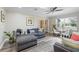 A neutral living room with a gray sofa, natural light, modern decor, and hardwood floors at 6327 Emerson S Ave, St Petersburg, FL 33707