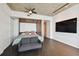 Modern bedroom featuring a murphy bed, hardwood floors, ceiling fan, and mounted TV at 777 N Ashley Dr # 2206, Tampa, FL 33602