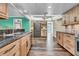 Well-lit kitchen featuring wood cabinets, granite countertops, stainless appliances, wood floors and skylight at 9034 127Th Ln, Seminole, FL 33776