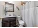 The bathroom features wood cabinets, a vanity, a framed mirror, and a shower with a shower curtain at 95 Georgia Ave, Crystal Beach, FL 34681