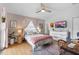 Cozy bedroom with a ceiling fan, neutral walls, natural light, and a seating area with writing desk at 95 Georgia Ave, Crystal Beach, FL 34681