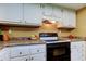Classic kitchen features white cabinets, granite counters, and a black range at 9769 86Th Ave # 9769, Seminole, FL 33777
