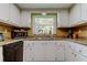 Bright kitchen with white cabinets, granite counters, and a sink beneath a window at 9769 86Th Ave # 9769, Seminole, FL 33777