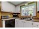 Kitchen area featuring double sink, window with a view, microwave and cabinet storage at 9769 86Th Ave # 9769, Seminole, FL 33777