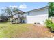 View of the home's backyard with a deck, patio, and well-maintained lawn at 1037 Jamaica Way, Tarpon Springs, FL 34689