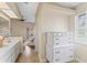Bright bathroom featuring a vanity, natural light, and hallway leading to bedroom with bunk beds at 1037 Jamaica Way, Tarpon Springs, FL 34689