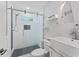 Modern bathroom showcasing sleek white tile, a glass-enclosed shower, and stylish fixtures for a clean look at 1037 Jamaica Way, Tarpon Springs, FL 34689