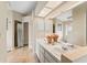 Bright bathroom featuring a double vanity, large mirror, and a separate shower area with a floral shower curtain at 1037 Jamaica Way, Tarpon Springs, FL 34689
