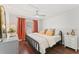 Cozy bedroom with hardwood floors, a black metal bed frame, and bright orange curtains for a warm feel at 1037 Jamaica Way, Tarpon Springs, FL 34689