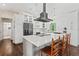 Bright kitchen features white cabinetry, modern appliances, large island, and hardwood floors at 1037 Jamaica Way, Tarpon Springs, FL 34689