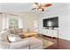 Comfortable living room with hardwood floors, sectional sofa, TV, and access to outdoor deck at 1037 Jamaica Way, Tarpon Springs, FL 34689