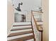 Staircase to the second floor, featuring hardwood steps, white risers, and an ornate wooden railing at 1037 Jamaica Way, Tarpon Springs, FL 34689
