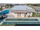Aerial view of community building with shuffleboard courts and pool surrounded by trees and landscaping at 11511 113Th St # 22E, Largo, FL 33778