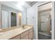 Bathroom featuring a granite vanity top, a large mirror, and a glass-enclosed shower at 11511 113Th St # 22E, Largo, FL 33778