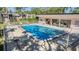 Inviting community pool surrounded by lounge chairs and tables, perfect for socializing and enjoying the outdoors at 11511 113Th St # 22E, Largo, FL 33778