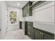 Bright laundry room with custom olive cabinetry, gold hardware, undermount sink, and large window for natural light at 116 19Th Se Ave, St Petersburg, FL 33705