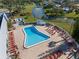 Aerial view showcasing the community pool with sun loungers and a hot tub in a well-maintained recreational area at 11719 Boynton Lane, New Port Richey, FL 34654