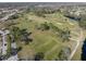 Aerial view showcasing the community golf course with lush green fairways and mature trees at 11719 Boynton Lane, New Port Richey, FL 34654