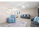 Comfortable living room with a striped armchair, soft carpet, and bright natural light at 11719 Boynton Lane, New Port Richey, FL 34654