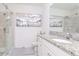 Bathroom featuring glass shower door, white cabinets, and stylish granite countertops at 12103 Gothic Rd, Spring Hill, FL 34610