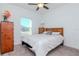 Cozy bedroom features a wood bed frame, dresser, and ceiling fan at 12103 Gothic Rd, Spring Hill, FL 34610