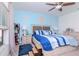 Bright bedroom featuring blue accent wall, ceiling fan, and comfortable queen bed at 12103 Gothic Rd, Spring Hill, FL 34610