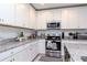 Close-up of kitchen featuring granite countertops, stainless appliances and ample white cabinet space at 12103 Gothic Rd, Spring Hill, FL 34610