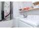 Well-lit laundry room with washer, dryer, shelving, and storage cabinets at 12103 Gothic Rd, Spring Hill, FL 34610
