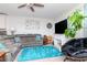 Comfortable living room with gray sectional, ceiling fan, and bright blue rug at 12103 Gothic Rd, Spring Hill, FL 34610