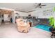 Open-concept living room flows into kitchen with white cabinetry and stainless steel appliances at 12103 Gothic Rd, Spring Hill, FL 34610