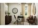 Comfortable home office featuring a dark wooden desk, modern decor, and a set of chairs near a sunlit window at 12410 Sweet Angel Aura Way, Parrish, FL 34219